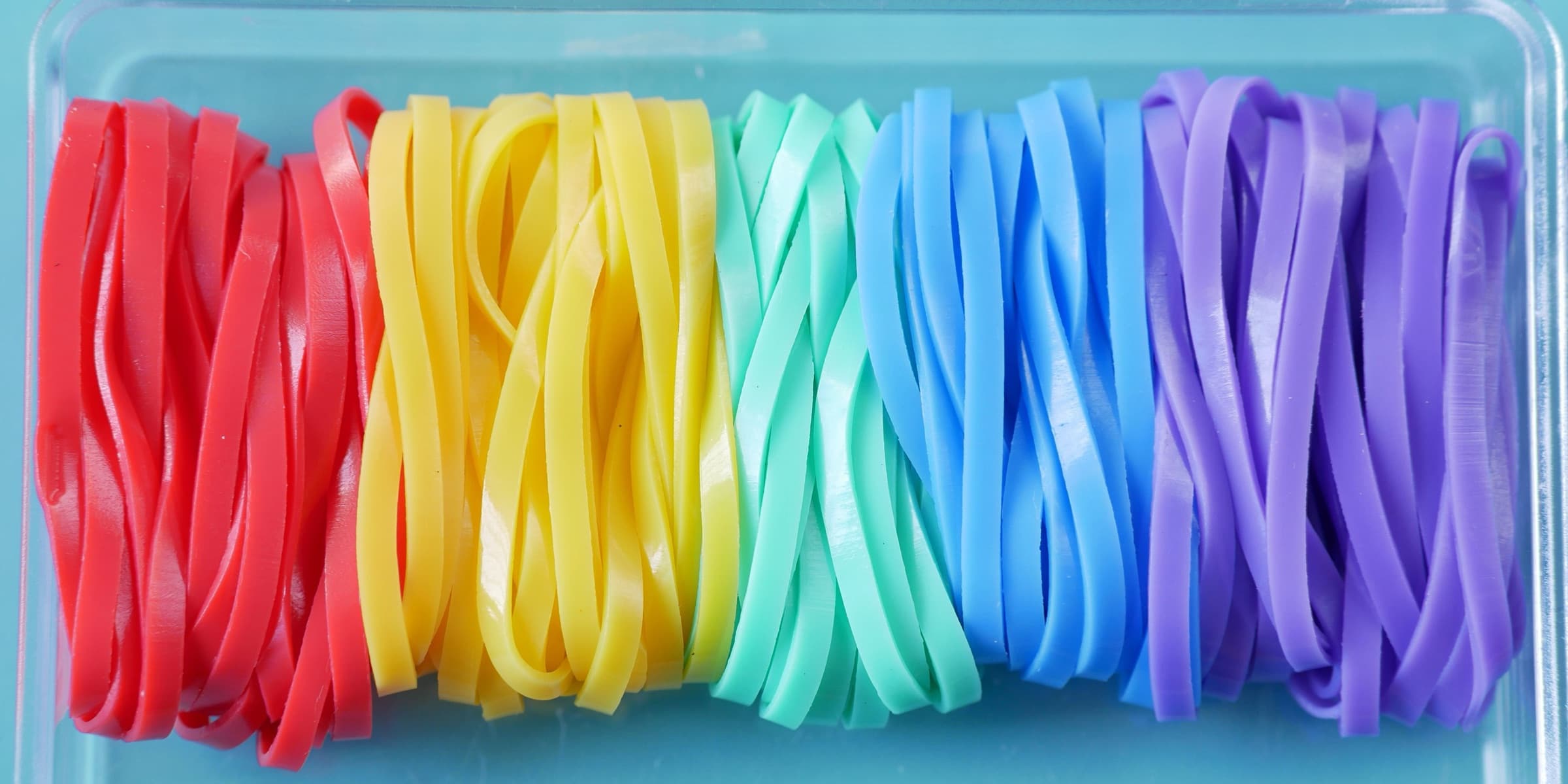 Multicoloured rubber bands in a clear box